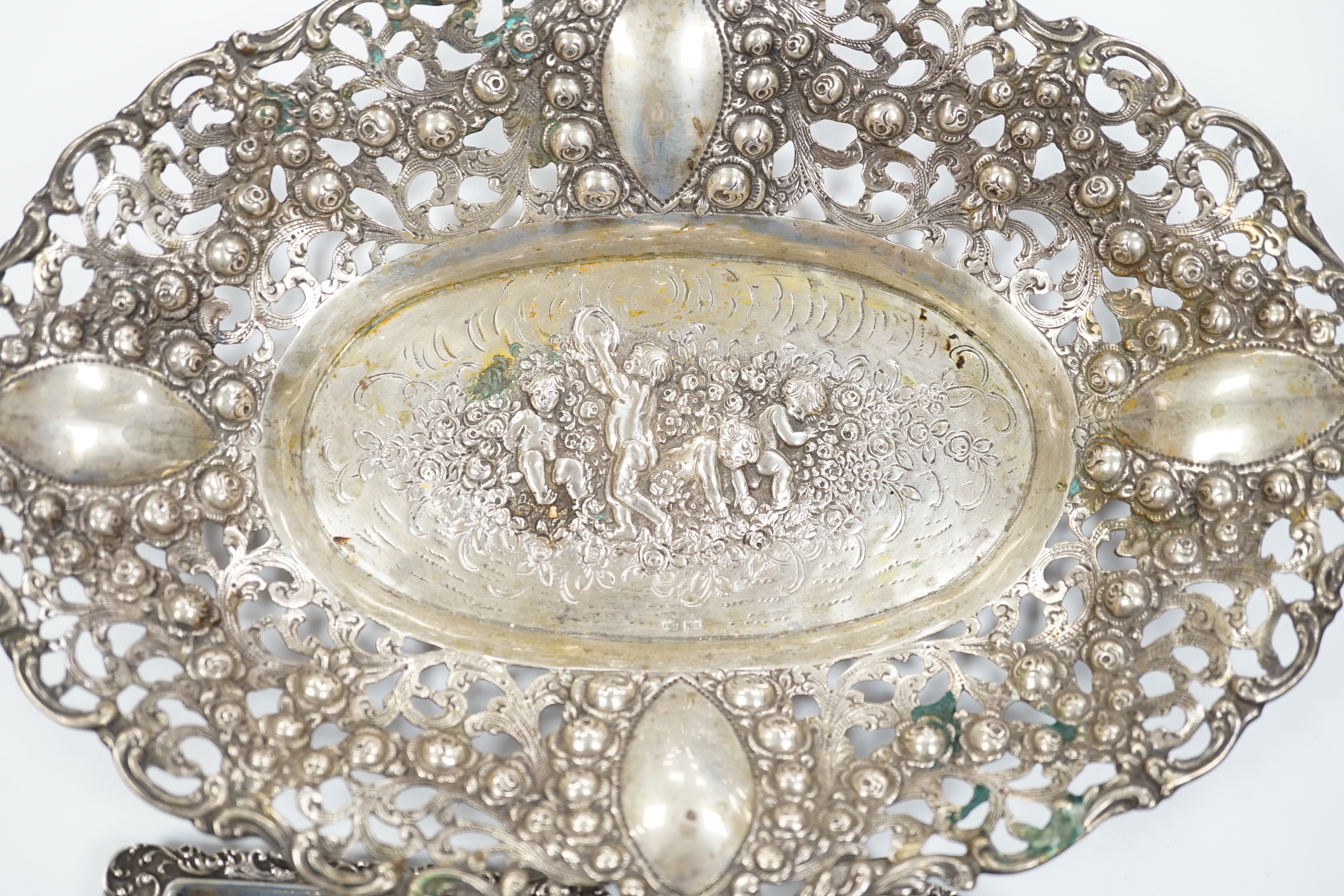 A German pierced 800 white metal oval dish, 28.4cm, three Dutch white metal ashtrays and an 835 white metal lighter.